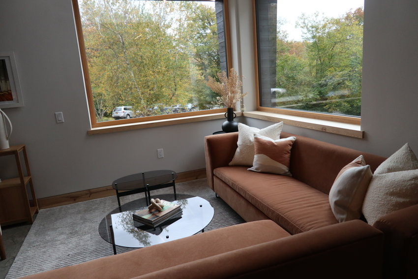 The interior floor plan is open and features warm and bright spaces designed with large high-tech windows that bring the outside in. This sitting area is open to the floor above.